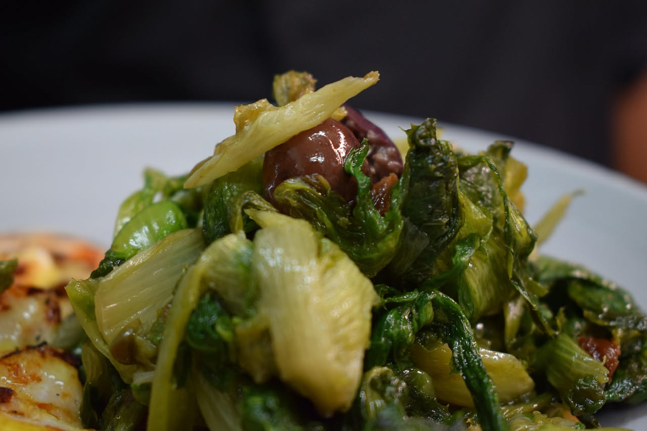 Finocchi tagliati in striscie gialle e bianche in una ciotola di ceramica bianca con salsa agrodolce lucida che li ricopre parzialmente
