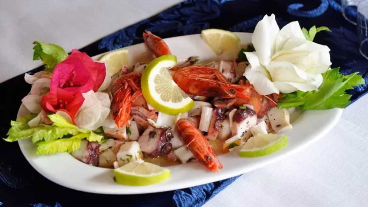 Vassoio di ostriche aperte con interno nacarato, vongole veraci intere, ricci di mare freschi e fette di limone su ghiaccio tritato