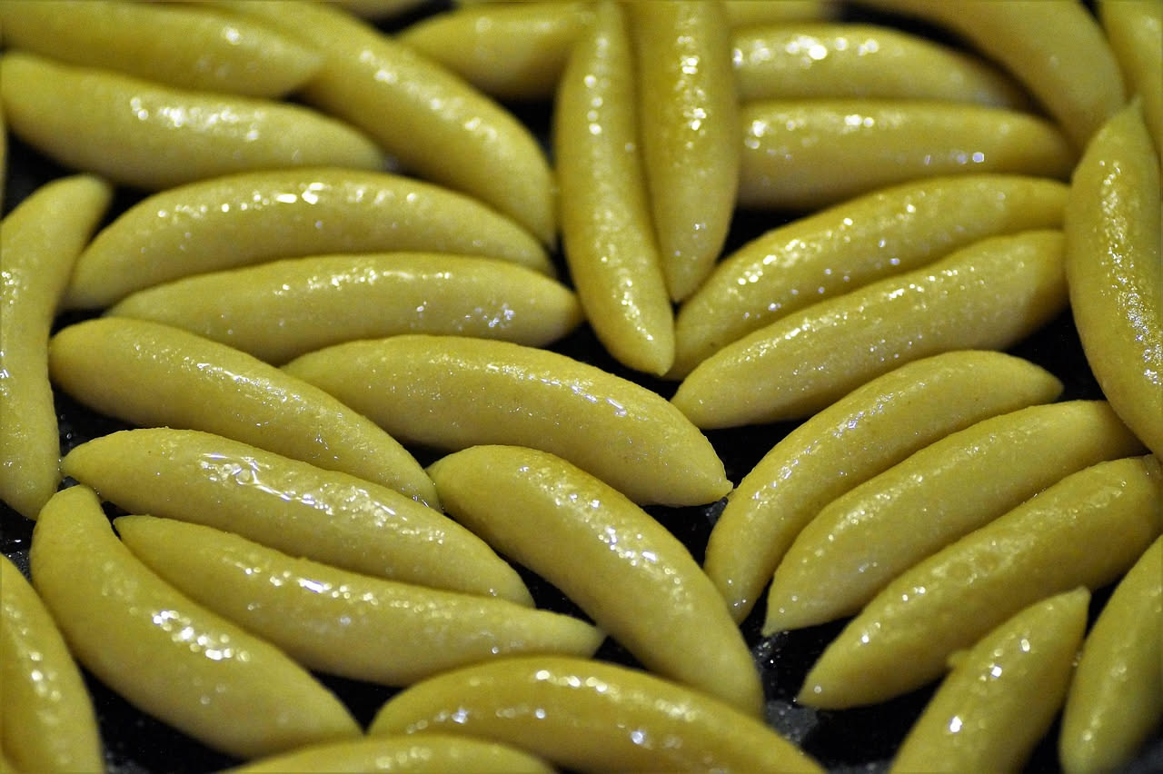 Giuggiolena a fette su un piatto bianco, pasta dolce marrone dorato con spezie visibili, accanto a un cucchiaio di miele