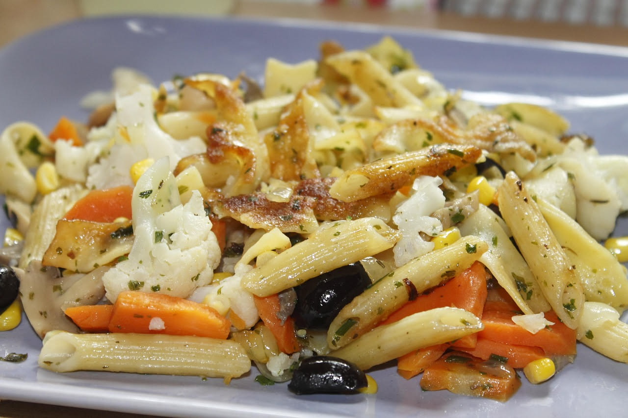 Padella con pappacelle trifolate: strisce di peperoni verdi leggermente dorate, aglio minuzzato, prezzemolo fresco verde, olio lucido sulla superficie