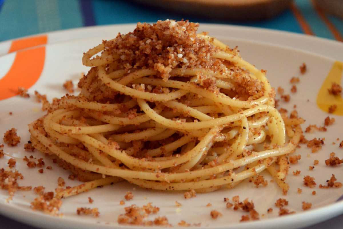 Piatto di spaghetti con sarde fresche, zafferano e finocchio selvatico, conditi con olio d'oliva e guarniti con un pizzico di pepe nero
