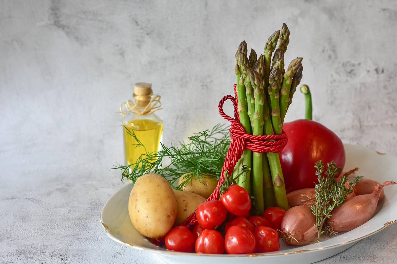 Ciotola di acquacotta di verdure con ortaggi a dadini colorati, pomodori rossi, zucchine verdi, pane tostato galleggiante in superficie e filo di olio extravergine