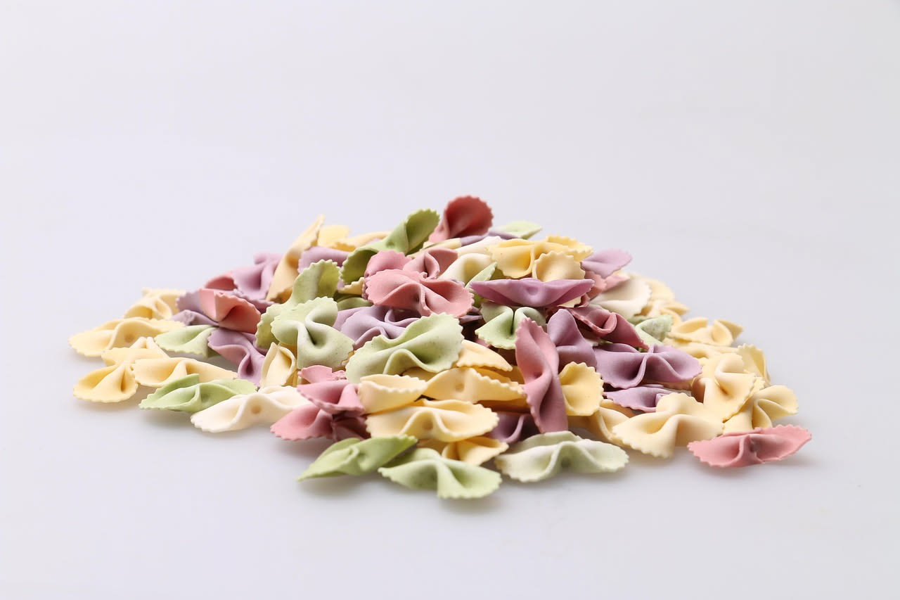 Agnolotti del plin in un piatto di brodo chiaro, con la caratteristica piega sul bordo, coperti di parmigiano grattugiato e parsimonia di burro