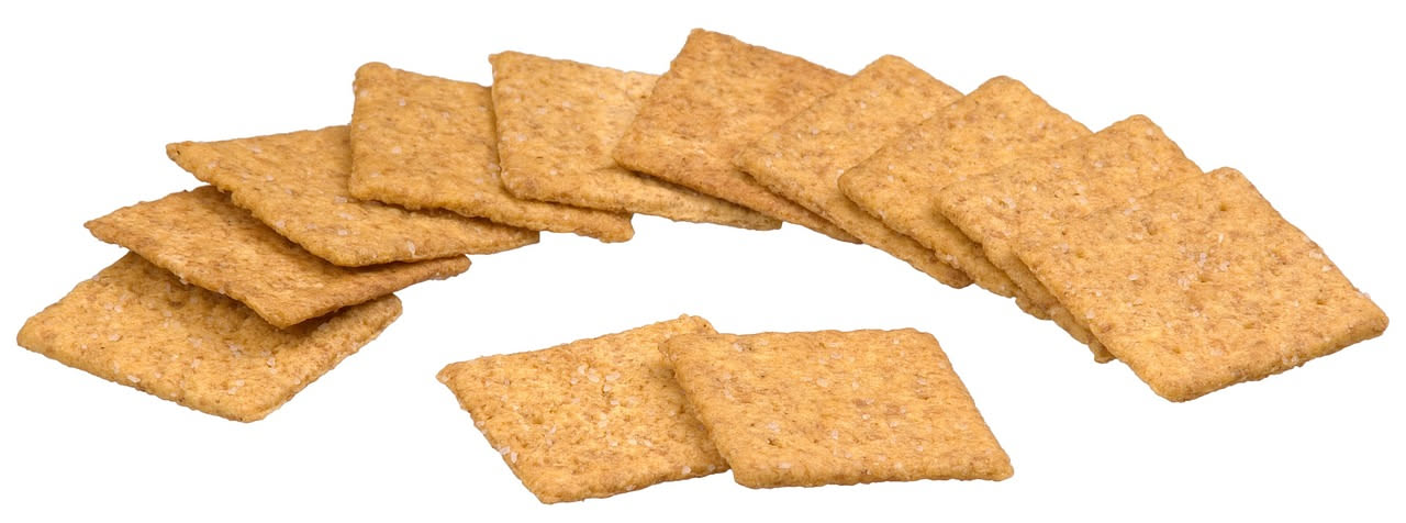 Biscottini salati dorati e croccanti disposti su un piatto bianco, con semi di sesamo e formaggio grattugiato visibili sulla superficie