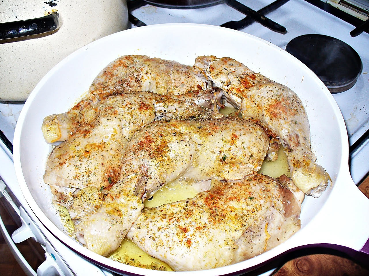 Una ciotola bianca di minestra fumante con brodo trasparente, pasta corta dorata e pezzetti di pollo, guarnita con prezzemolo fresco tritato