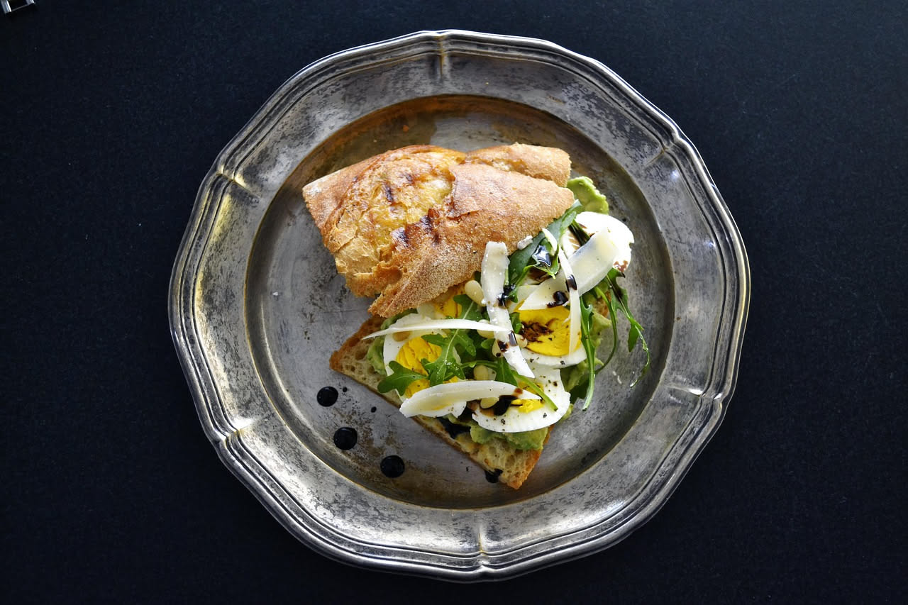 Piatto di cacio e ova con uova intere cremose immerse in formaggio filante, colore giallo oro, accompagnate da pane tostato marrone