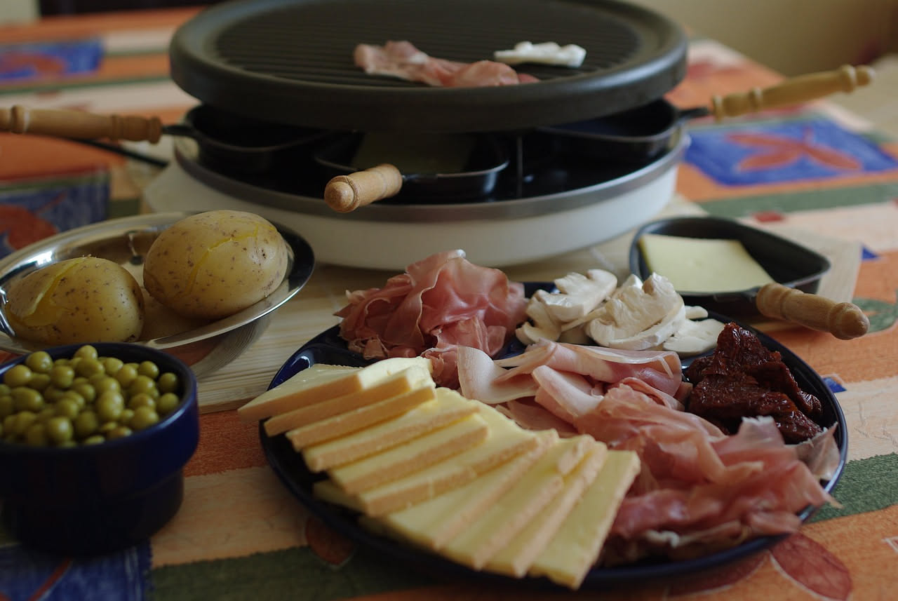 Fette di caciocavallo grigliate disposte su un piatto bianco, dorate e croccanti alla superficie, con tracce scure di griglia, accompagnate da limone fresco e peperoncino rosso.