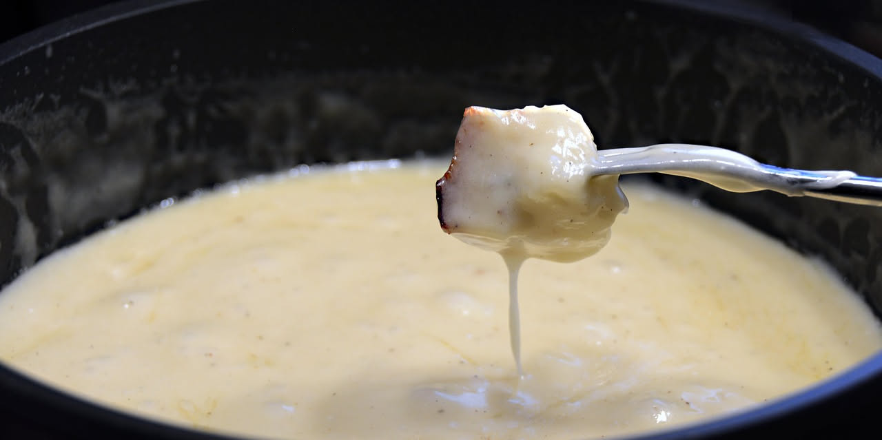 Caciocavallo affumicato alle braci, crosta dorata e scura, servito intero su un piatto bianco con fette di pane tostato e limone al lato