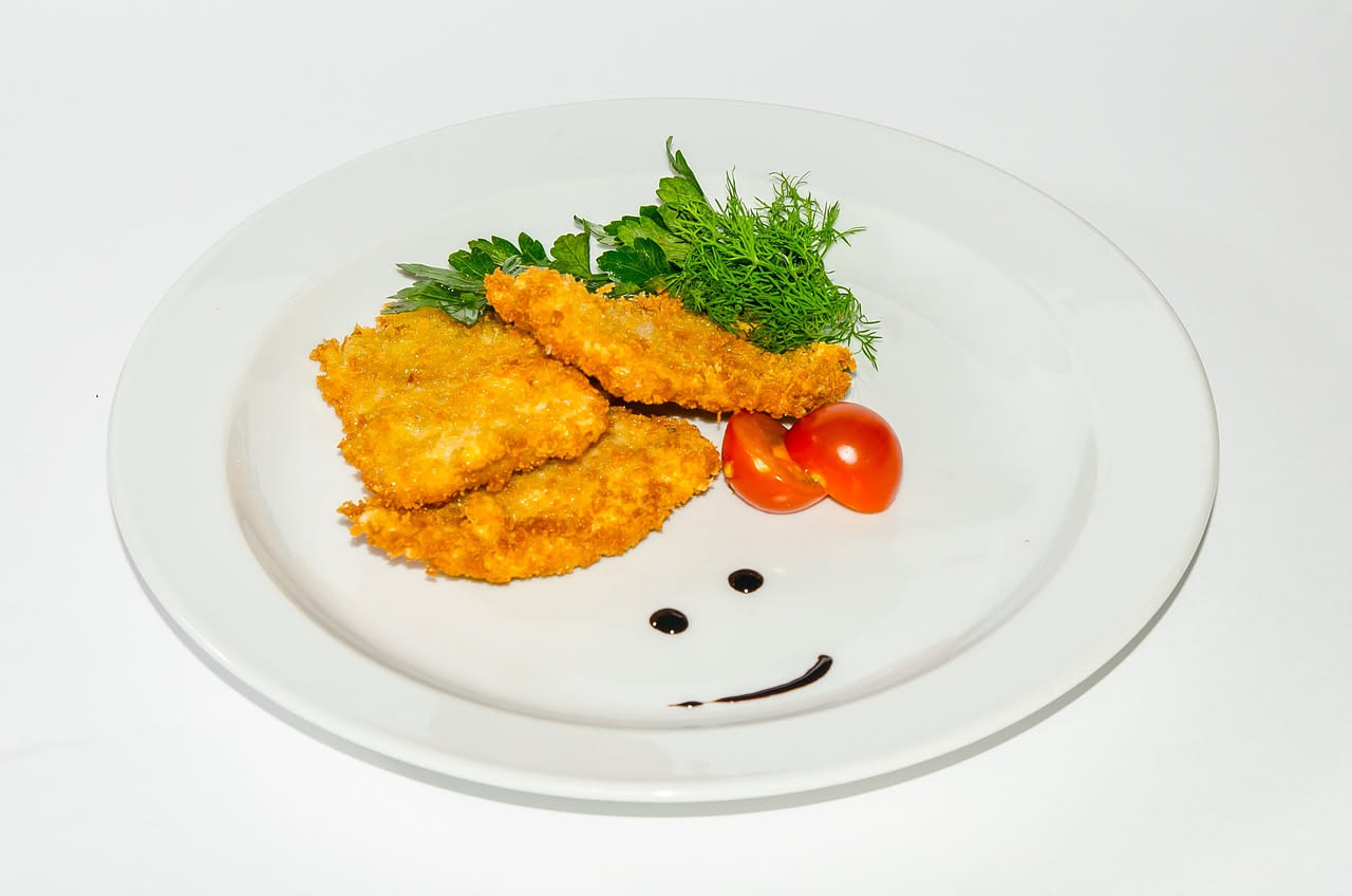 Fette di caciocavallo fritto dorate e croccanti, appena scolate su carta assorbente, accanto a una ciotola di marinara rossa, su piatto bianco con bordo sottile