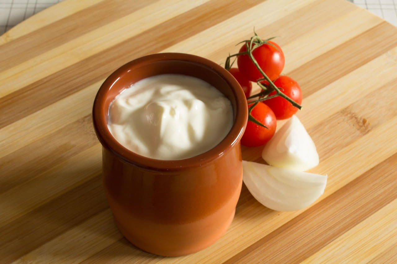 Casatella trevigiana affettata nel piatto, con interno cremoso bianco e giallo dalla ricotta e dalla frutta candita, superficie ricoperta di Pan di Spagna dorato, guarnita da frutta candita rossa e gi