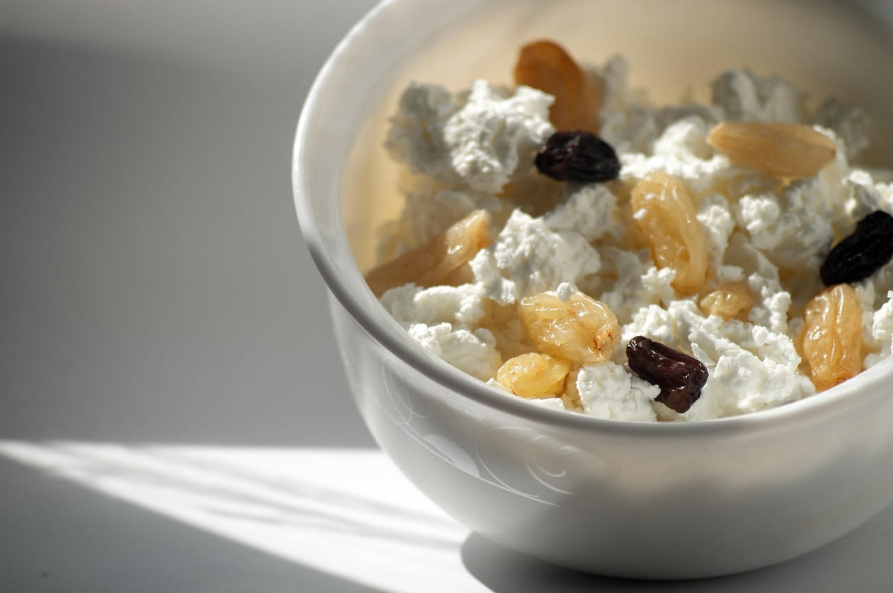 Ricotta affumicata casizolu in una forma di vimini, colore marrone nocciola, superficie affumicata, posta su un panno di lino bianco con sfondo di legno invecchiato