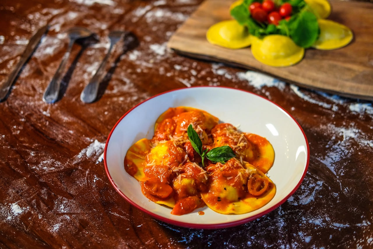 Una cocciula rotonda con crosta dorata e croccante, tagliata a metà su un tagliere di legno, con la mollica bianca e ariosa ben visibile, circondata da spighe di grano