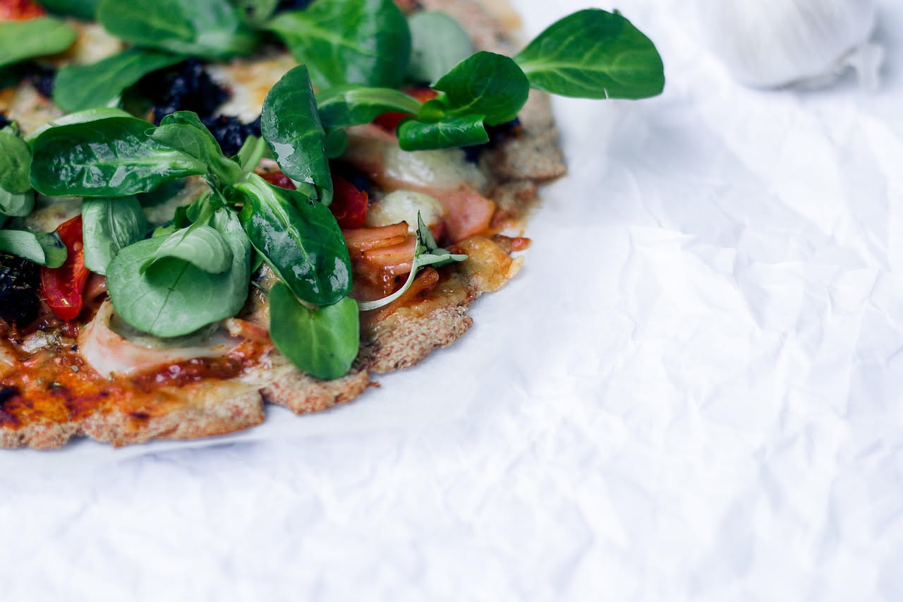 Crescia salata appena sfornata, dorata in superficie, tagliata a metà su una tavola di legno. Crosta croccante color oro, interno soffice e filante con visibili inclusioni di formaggio.