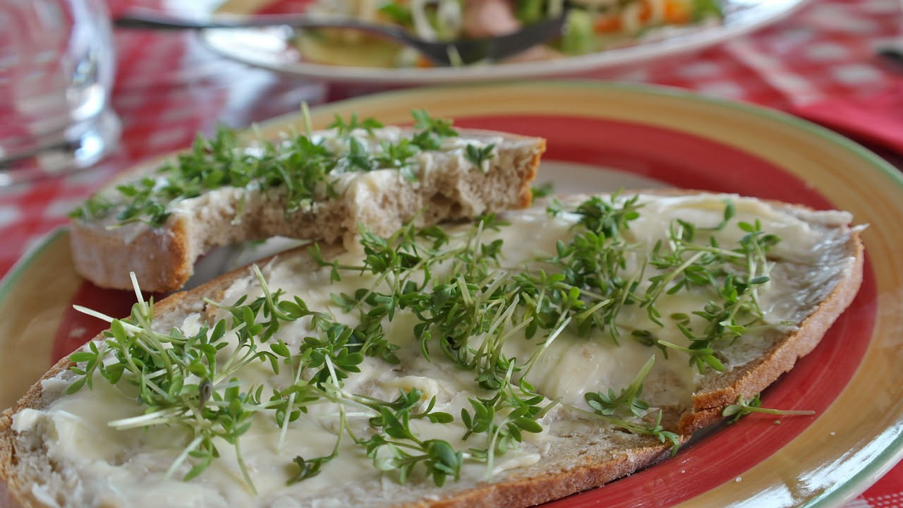 Crescione di magro appena sfornato, dorato in superficie, tagliato a fette di mezzo centimetro, ripieno visibile con verdure verdi e lenticchie, servito su piatto bianco con un filo di olio d'oliva