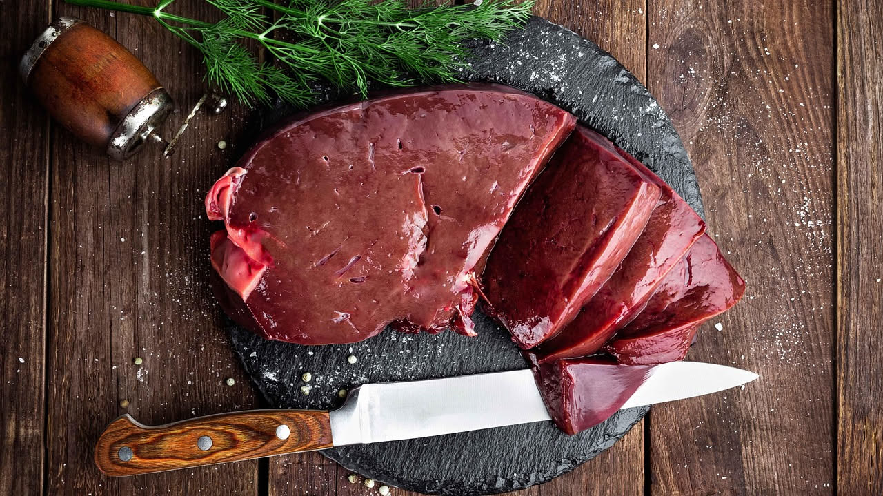 Fegatelli toscani cotti in umido con salsa scura su piatto bianco, decorati con rami di rosmarino fresco e finocchio selvatico