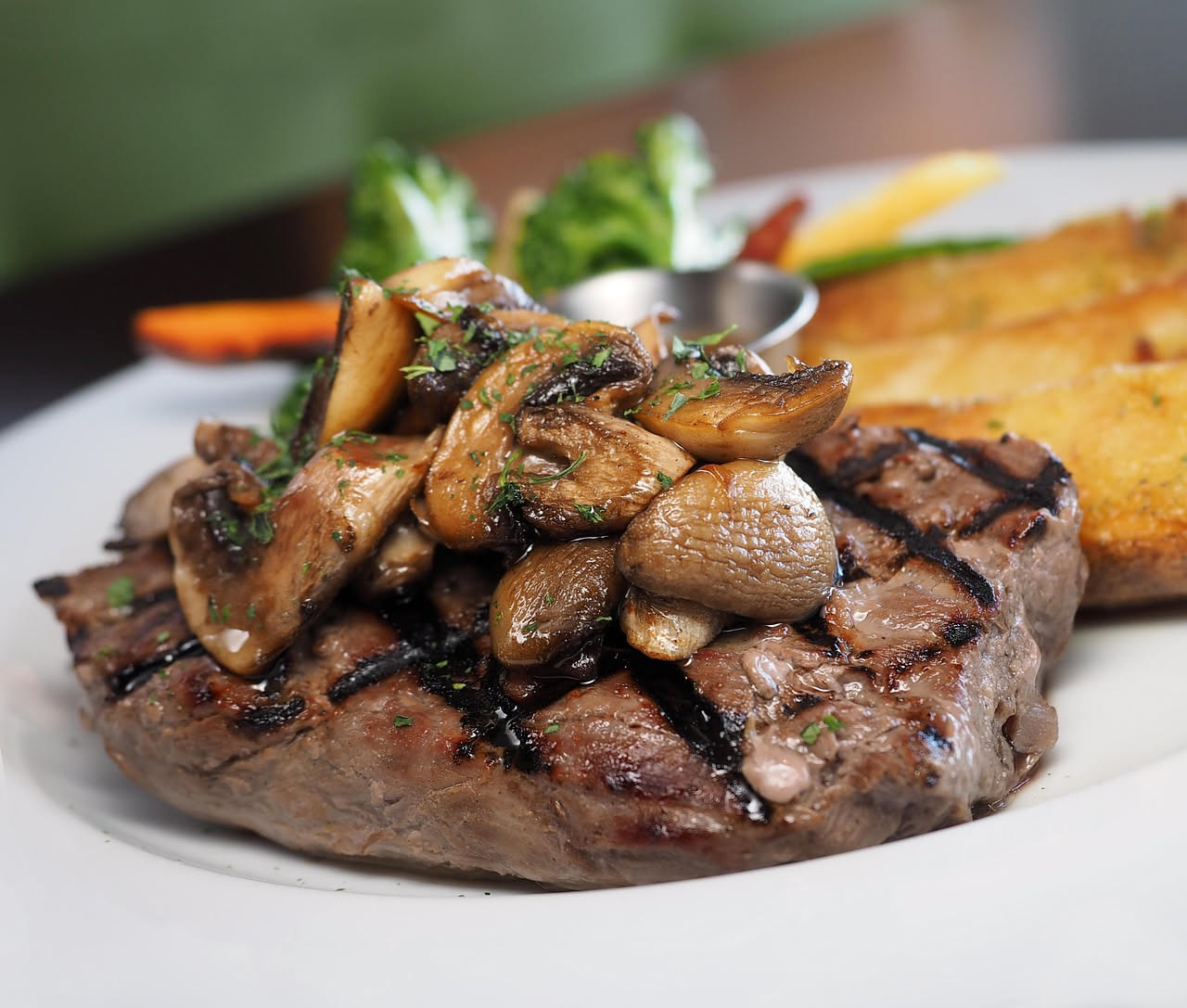 Fegato alla marsalese in piatto bianco: fette dorate di fegato di vitello ricoperte da salsa bruna al Marsala, con cipolla trasparente e pepe nero, contorno di prezzemolo fresco