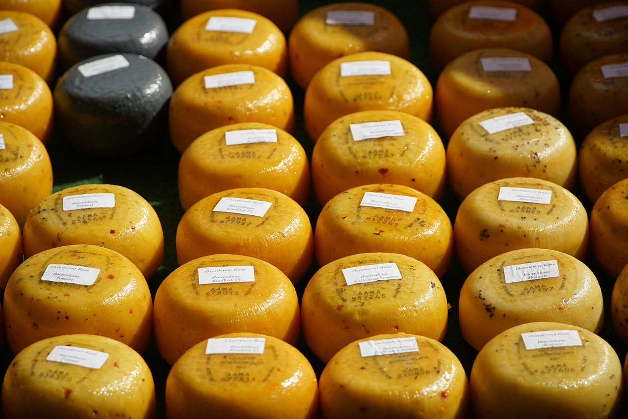 Formagella della Val di Sole: formaggio cilindrico a pasta cruda, colore giallo paglierino, spigoli netti, appoggiato su una tavola di legno scuro con un coltello per formaggi accanto