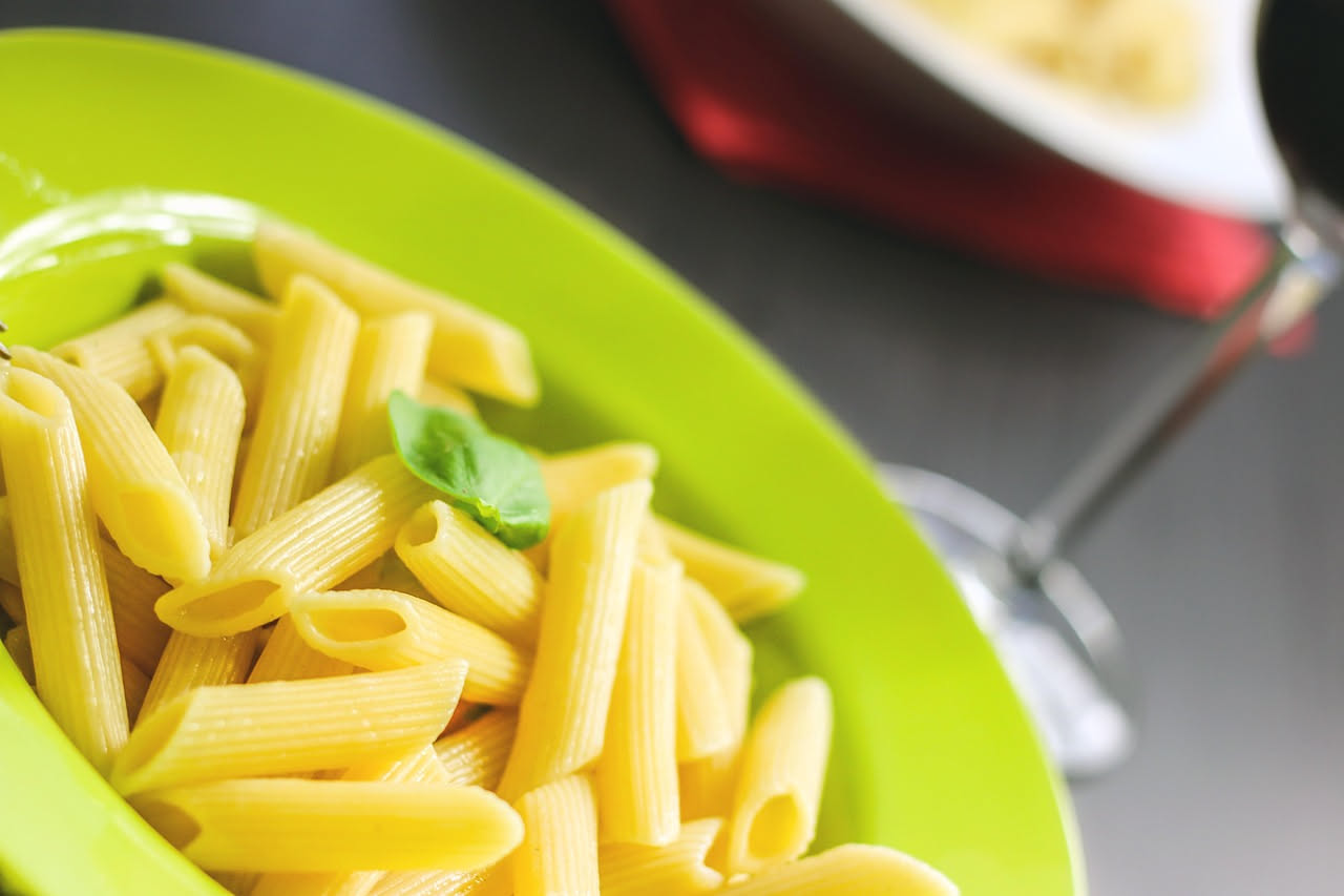 Fritatelle di pasta dorate e croccanti in un piatto bianco, guarnite con prezzemolo fresco, vapore che sale dalla superficie, bordo dorato intenso visibile