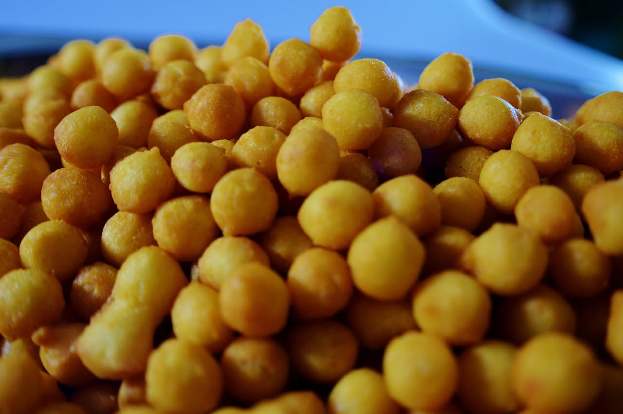 Gnocchi fritti dorati e croccanti in un piatto bianco, spolverati di sale grosso e prezzemolo fresco, con una ciotola di salsa di pomodoro accanto