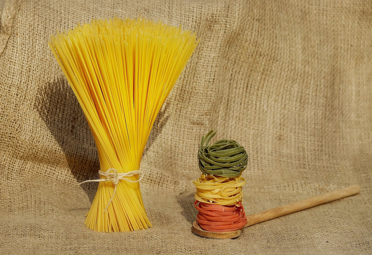 Linguine al prezzemolo fresco in piatto bianco, condite con aglio e olio, prezzemolo verde brillante sparso in superficie, limone fresco accanto al piatto