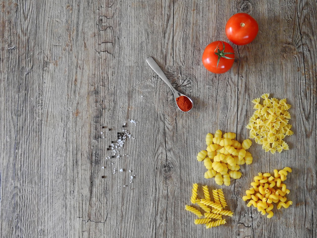 Piatto di malloreddus caldi, gnocchetti gialli di semola ricoperti di ragù rosso scuro e grattugiata di pecorino bianco, conditi con una foglia di prezzemolo fresco