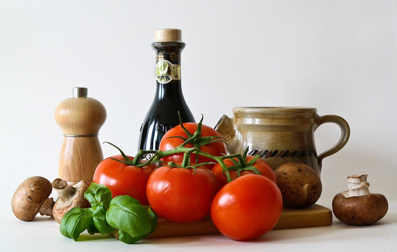 Melanzane alla basilicatese in piatto bianco: fette dorate e croccanti di melanzane fritte, condite con pomodori rossi, aglio, prezzemolo verde e olio, bordo del piatto pulito