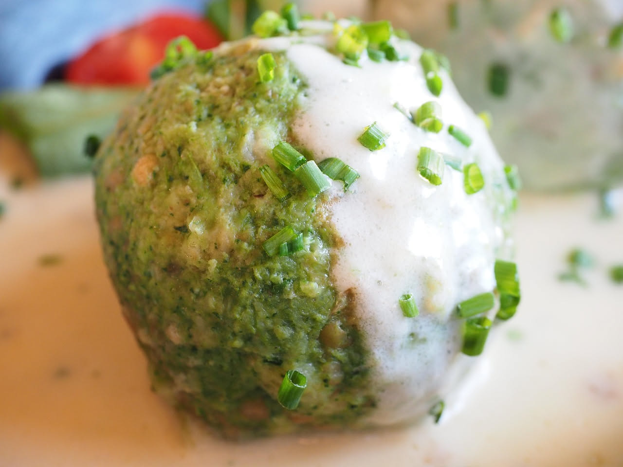 Tre mondeghili dorati e croccanti serviti in un piatto bianco, con colore marrone scuro e interno morbido visibile al taglio, contorno di prezzemolo fresco