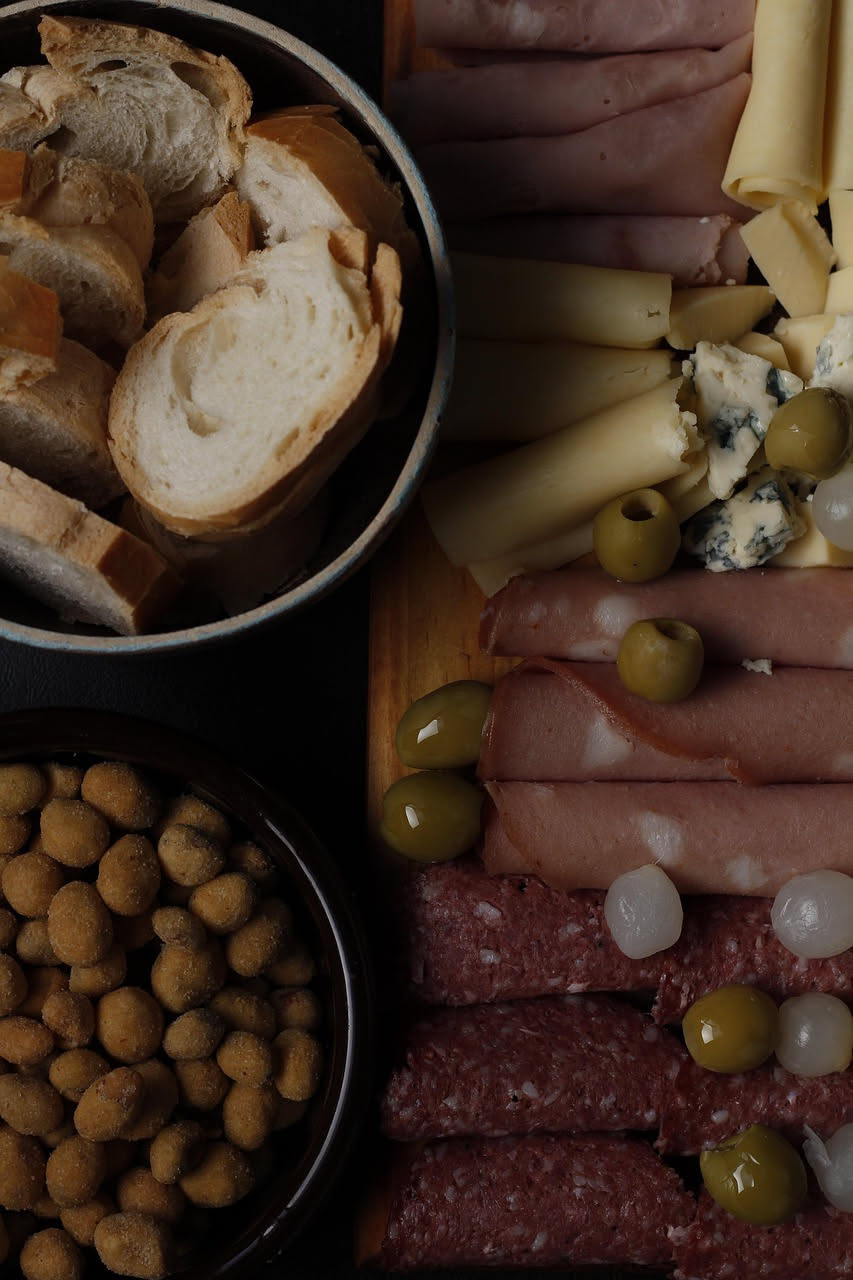 Fette di mortadella di Prato tagliate al coltello, con la caratteristica colorazione rosa scuro e le spezie visibili, su un piatto in ceramica bianca