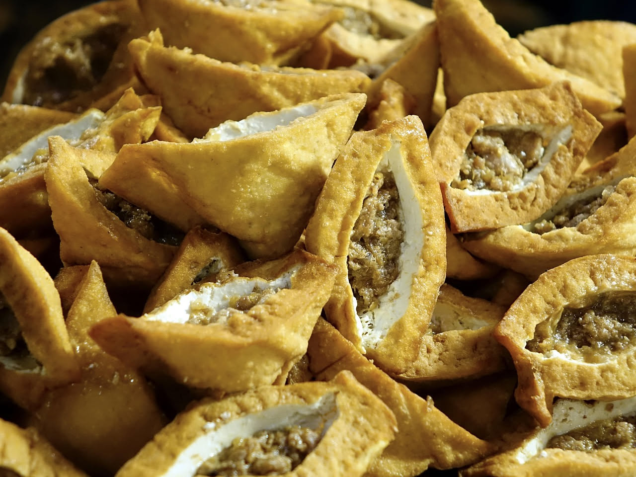 Musso intero fritto dorato e croccante su un piatto bianco con contorno di limone fresco affettato e prezzemolo verde, sfondo neutro