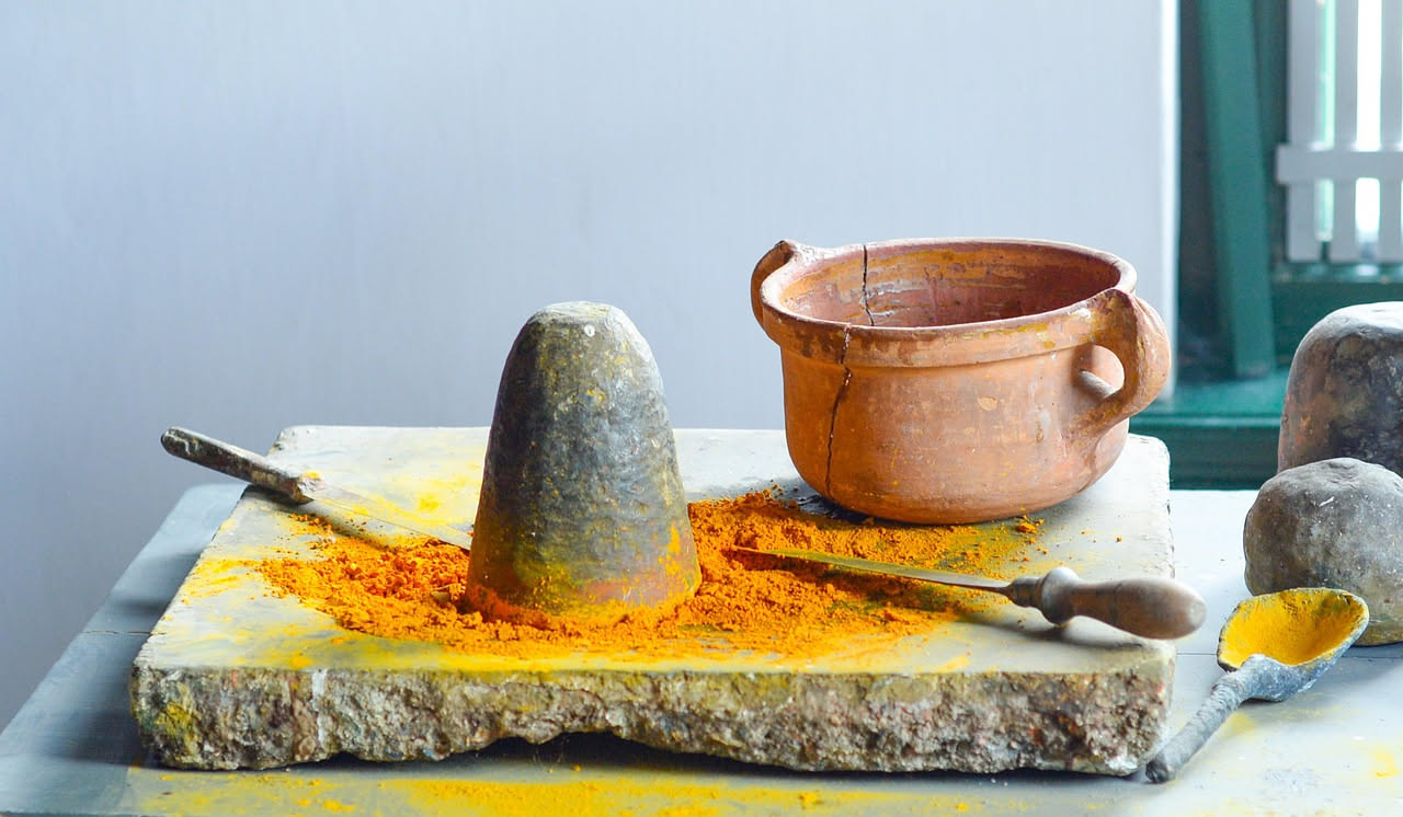 Nduja di Spilinga su fondo bianco: insaccato scuro rossiccio, cremoso, con goccioline visibili sulla superficie, tagliato a fette spesse che mostrano la consistenza morbida