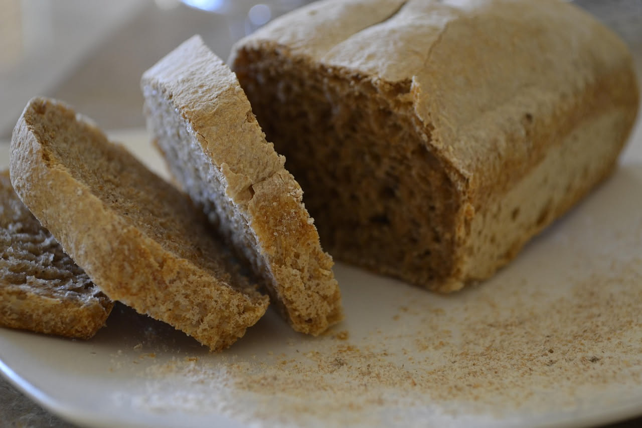 Bicchiere trasparente con orzata mantovana di colore bianco avorio, bevanda cremosa e omogenea, servita fredda con cubetti di ghiaccio e leggera schiuma in superficie