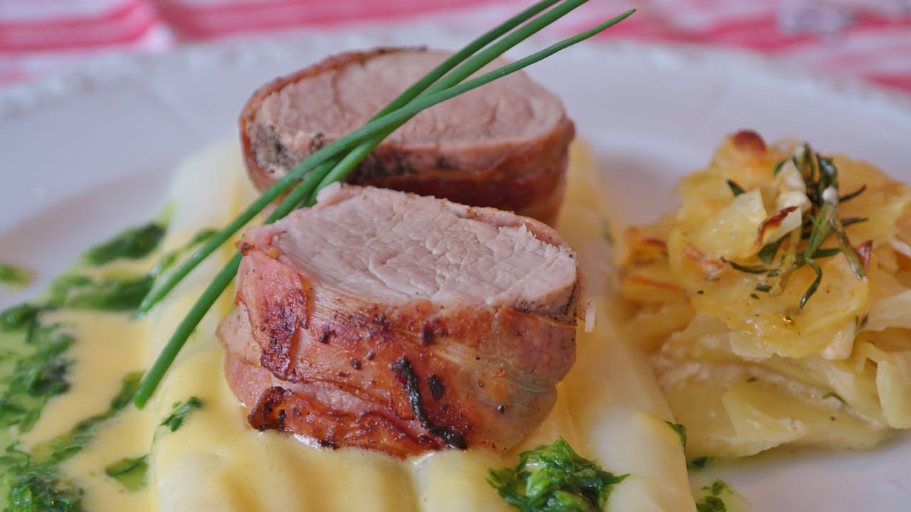 Pancetta di maiale croccante in padella, fette rigate dorate e croccanti con grasso leggermente traslucido, disposte su carta assorbente