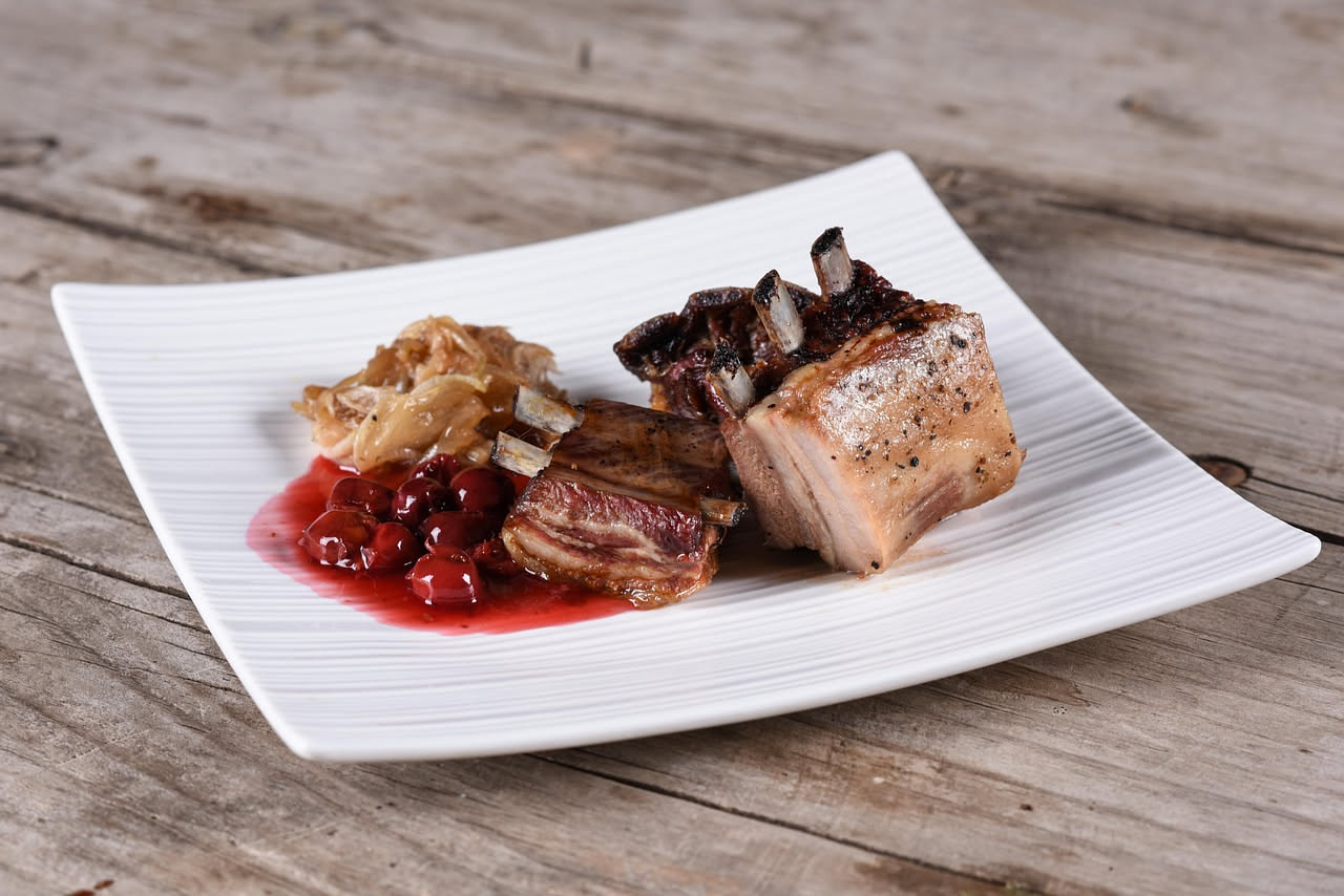Fette di pancetta tesa dorate e croccanti appoggiate su carta bianca, bordi arricciati leggermente scuri, superficie ben asciutta