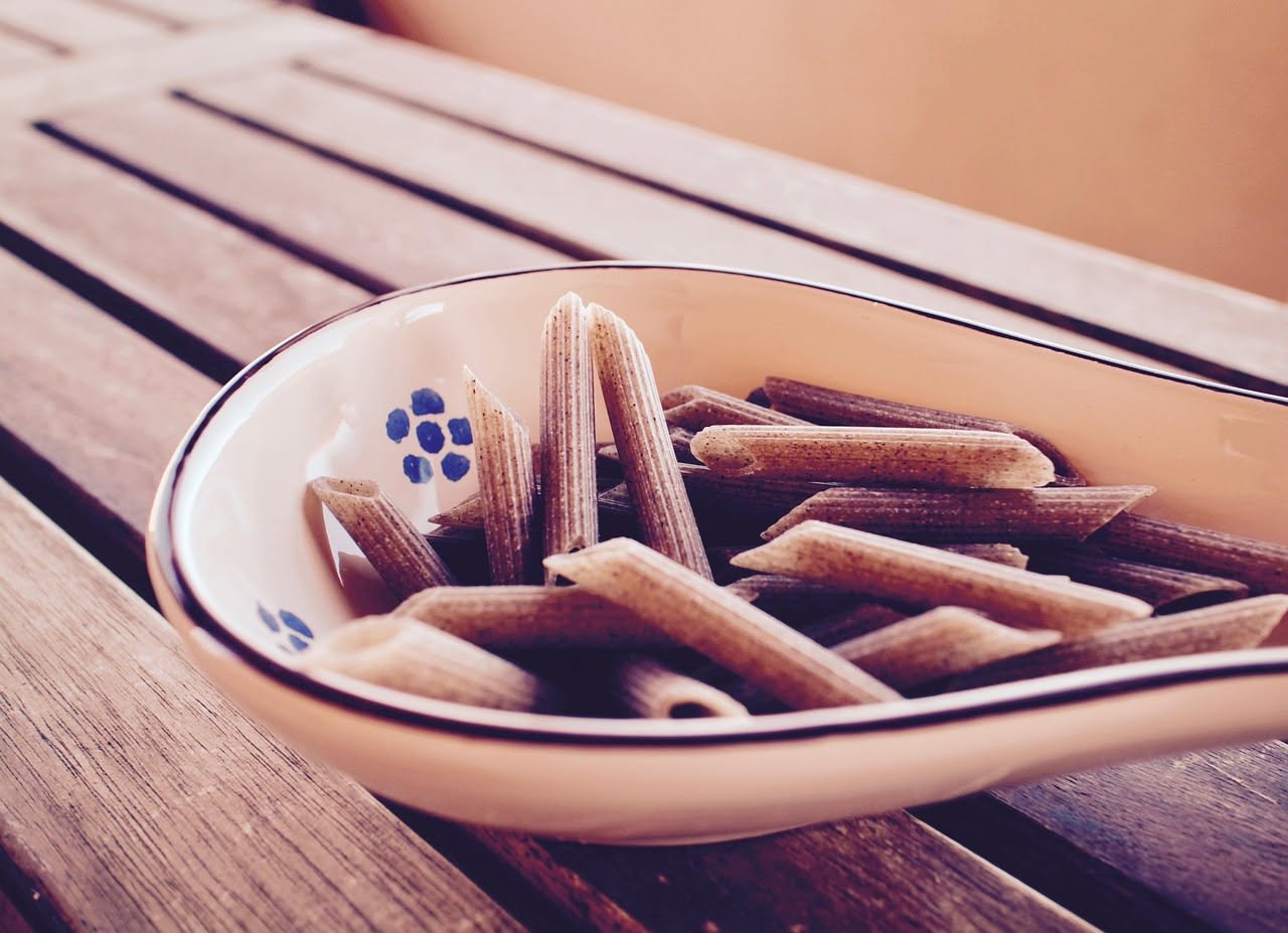 Piatto di pasta fresca con scaglie sottili di tartufo nero lucido, burro fuso e formaggio grattugiato, su piatto bianco in primo piano
