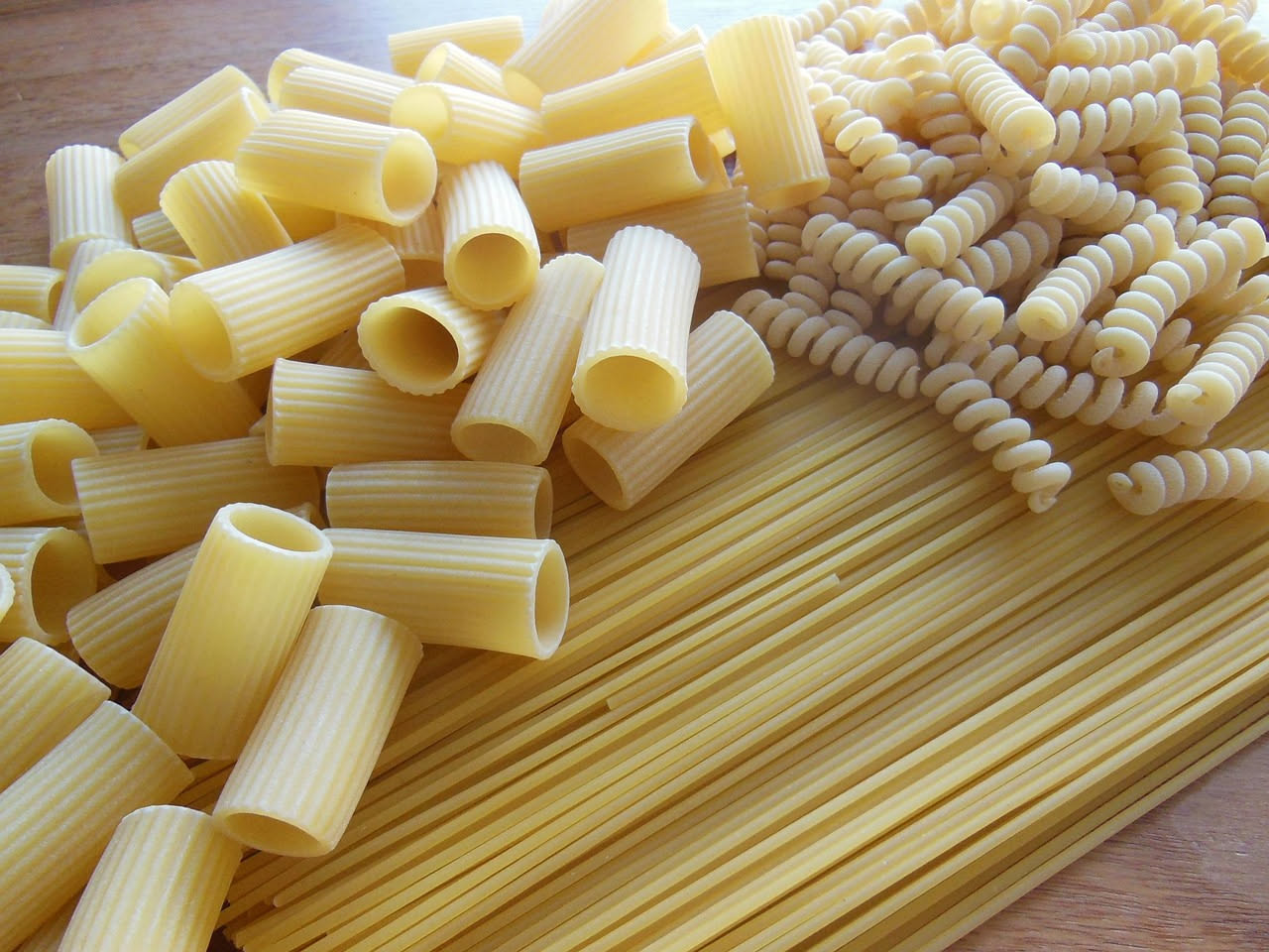 Un piatto di pasta e orzo mischiati in brodo, con verdure tagliate finemente, completato da un filo d'olio di oliva in superficie e prezzemolo fresco tritato