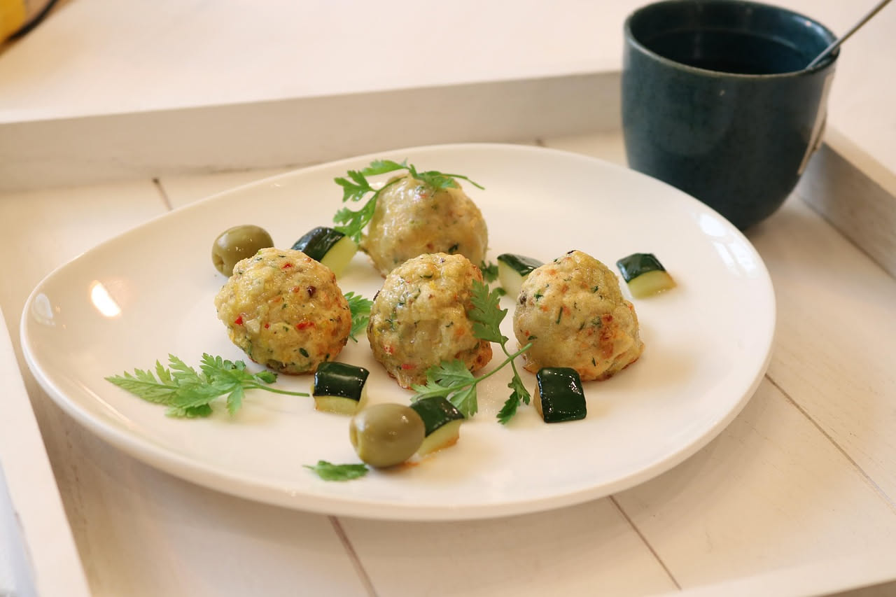 Tre pasticcini di verdure dorati e croccanti con sfoglia sfogliata, disposti su piatto bianco con guarnizione di erba cipollina fresca e gocce di olio d'oliva