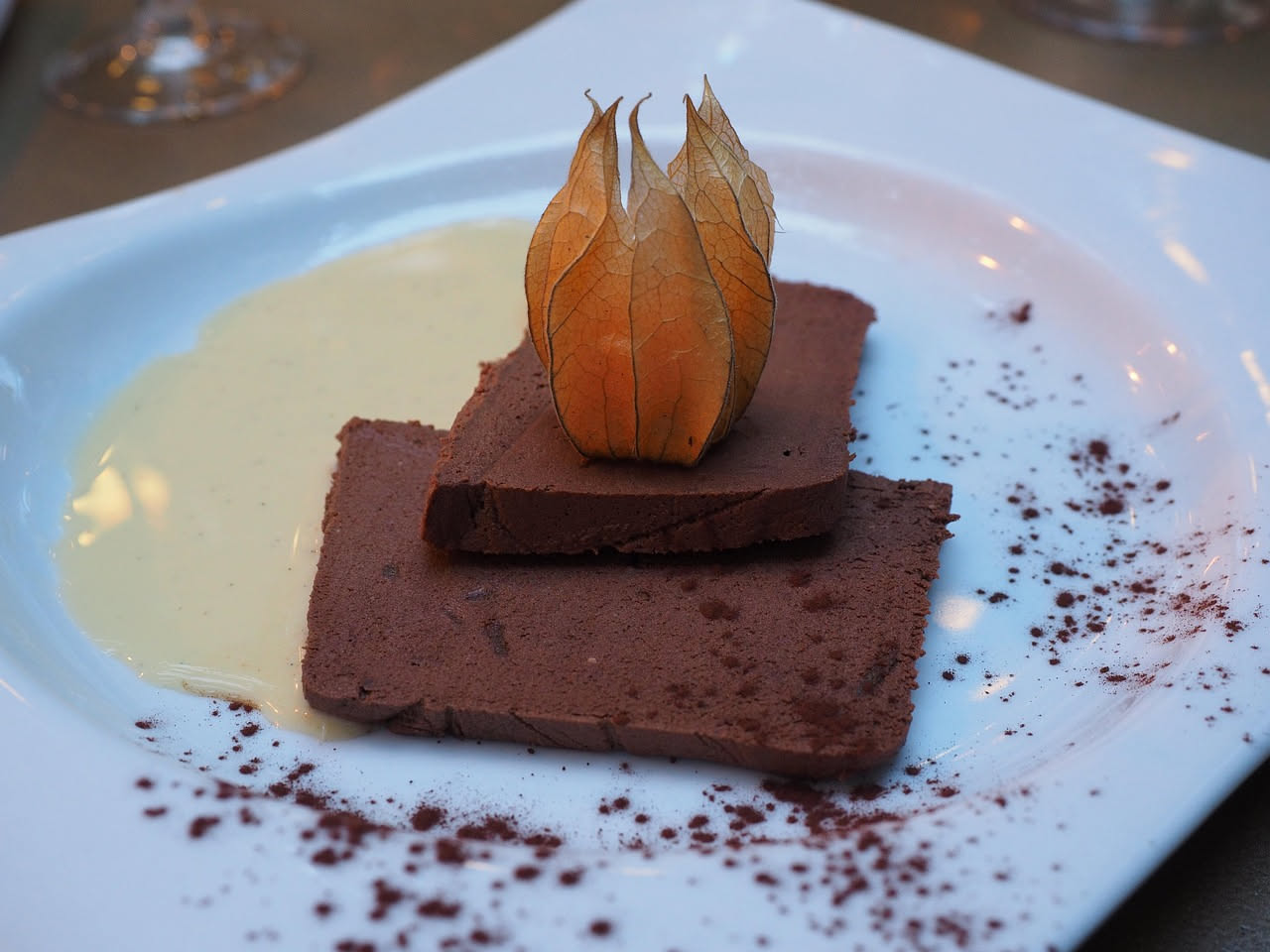 Paté di lepre marrone scuro e cremoso in una terrina di ceramica bianca, guarnito con un rametto di timo fresco, accompagnato da fette di pane tostato croccante e un coltello da burro d'argento