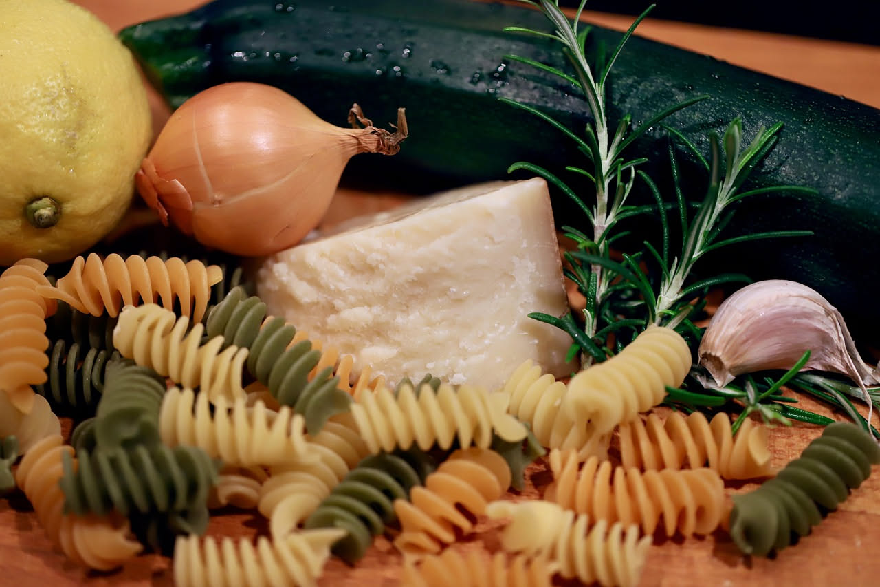 Cubo di pecorino stagionato color avorio con sfumature giallastre, appoggiato su un tagliere di legno accanto a pane casereccio tostato e miele scuro in una piccola ciotola