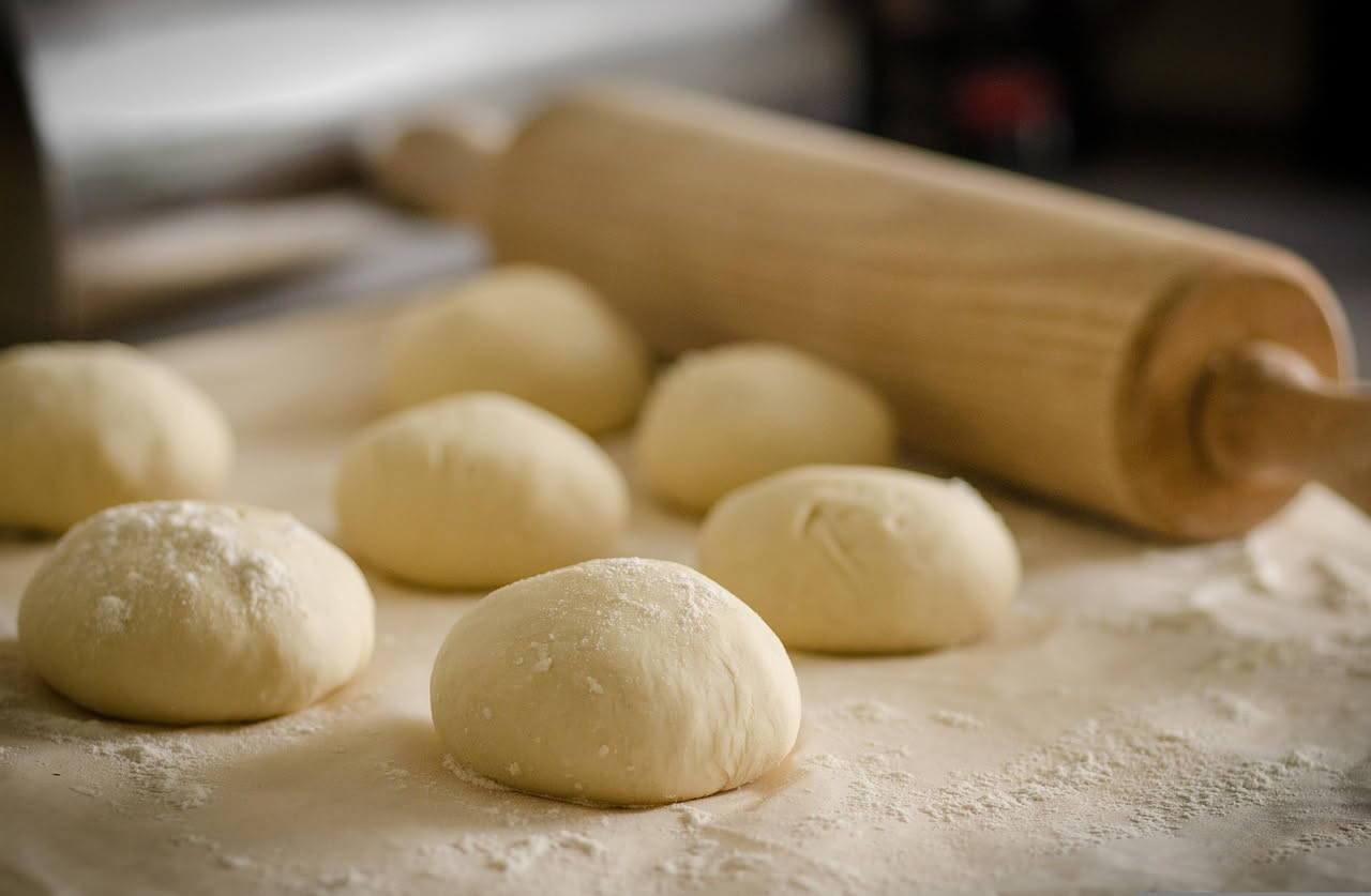 Pizzutelle dorate e croccanti disposte su un piatto bianco, ancora tiepide, coperte leggermente da uno strato di sale marino, con una trama visibile di bollicine dorate sulla superficie