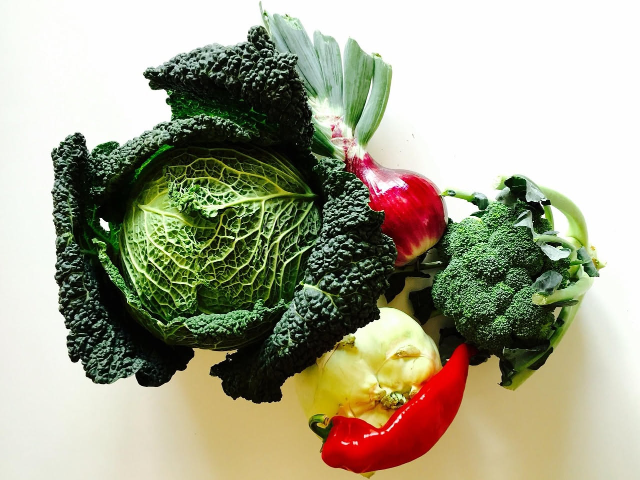 Ciotola di ribollita fredda con cubetti di pane raffermo, fagioli bianchi, cavolo nero e pomodori, condita con filo d'olio verde su tavolo rustico