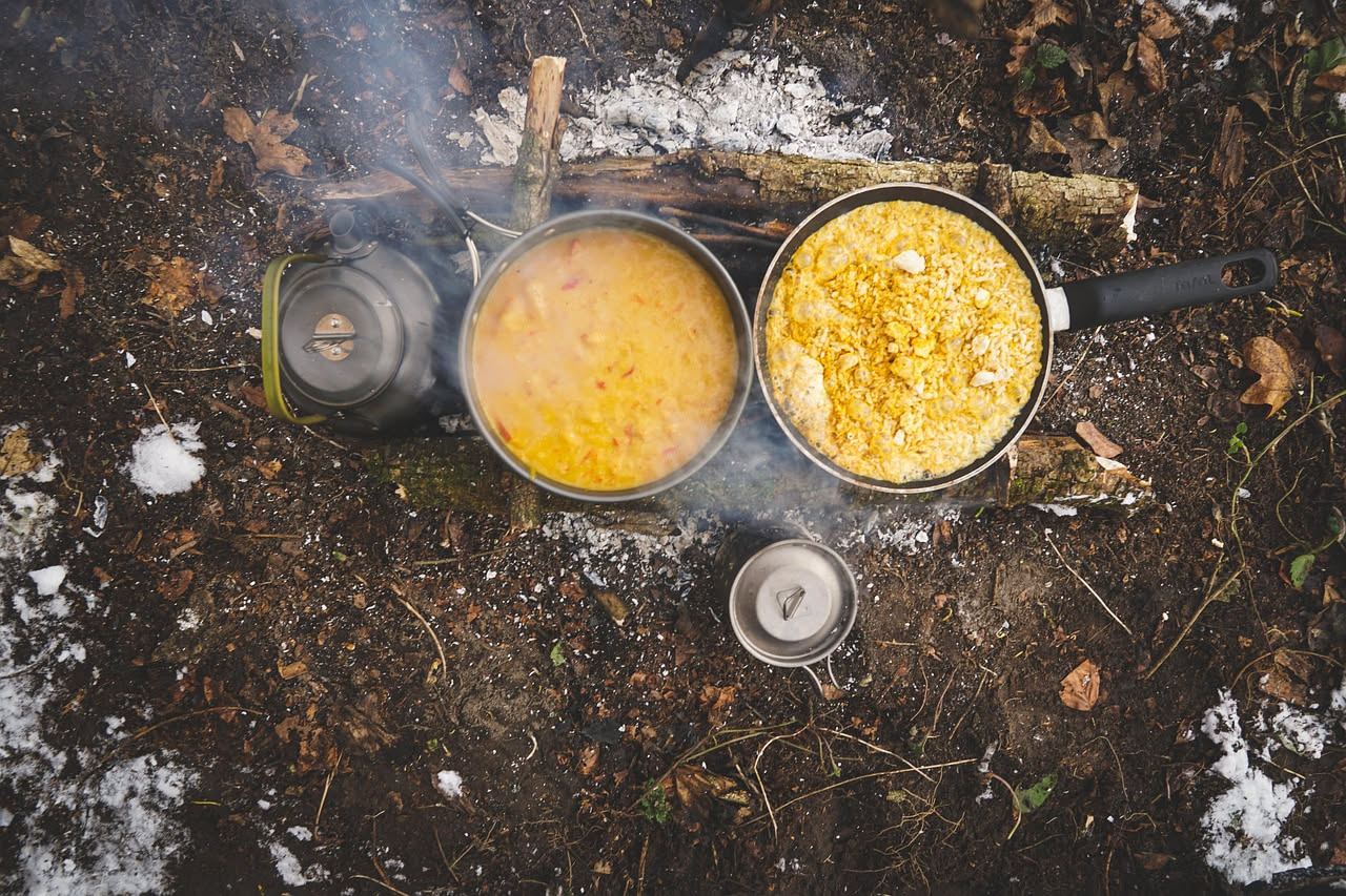 Risotto cremoso giallo-arancio servito in un piatto fondo bianco, con una nota di burro e parmigiano grattugiato in superficie, contornato da zucca cotta smembrata attorno al piatto