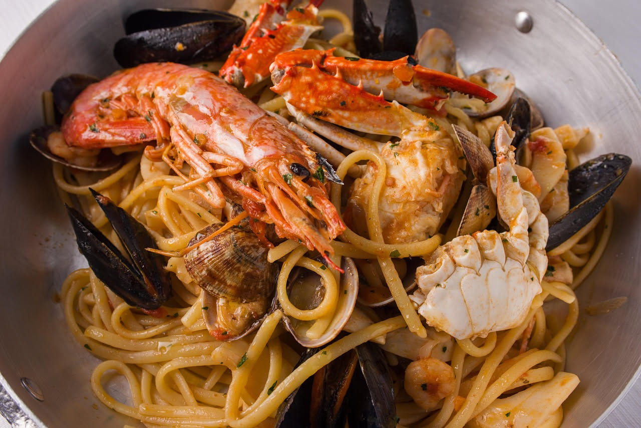 Piatto di scialatielli ai frutti di mare con vongole, mazzancolle e cozze, conditi con olio, aglio e prezzemolo fresco