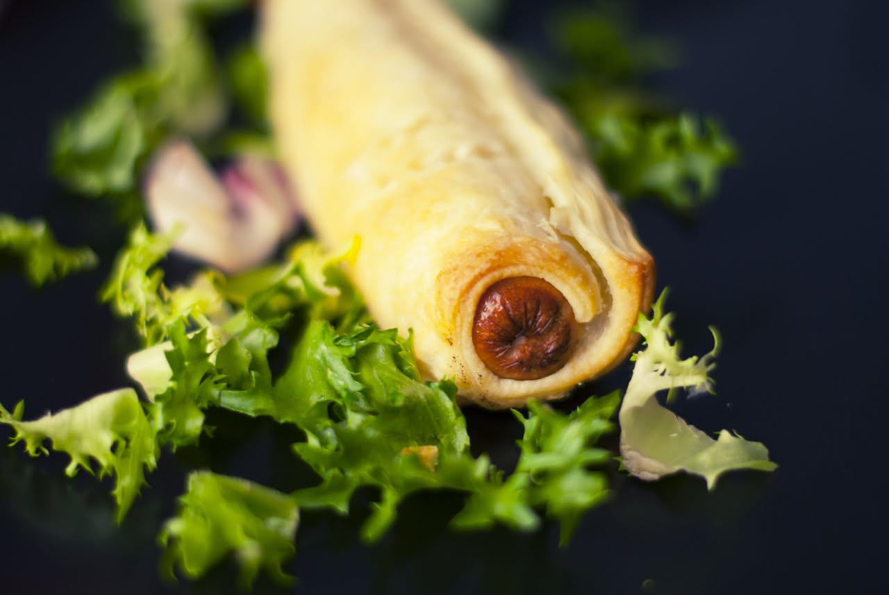 Sfoglia ripiena rettangolare appena sfornata, dorata e croccante, con bordi ben sigillati e una leggera spruzzata di zucchero a velo, servita su piatto bianco