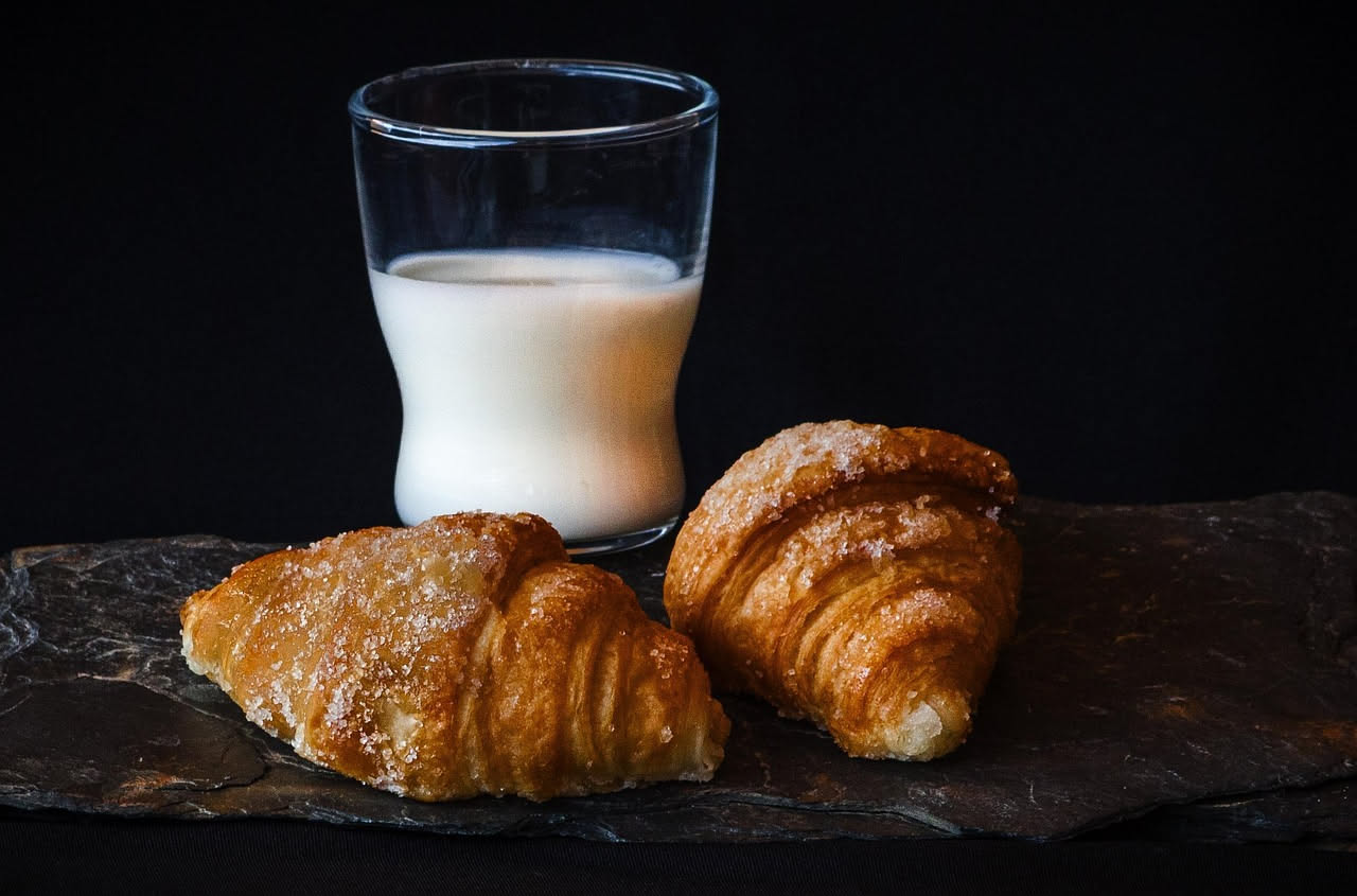 Tre sfogliatelle abruzzesi dorate e croccanti appoggiate su un piatto bianco, riprese da vicino, si vede la pasta sfoglia dorata e il ripieno di marmellata scura che affiora dalle aperture