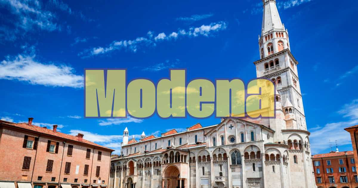 Fette di soppressata di Modena affettate sottilmente su un tavolo di legno, con colore rosso scuro uniforme e grasso visibile, accanto a pane e vino rosso