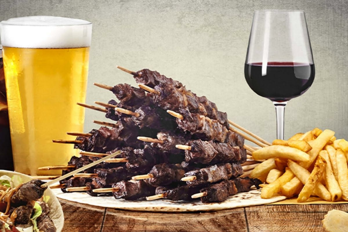 Spiedo vicentino affettato su un piatto bianco, si vedono strati di carni diverse, rognoni, e frattaglie dorate, vapore che sale, accompagnato da una salsa scura accanto
