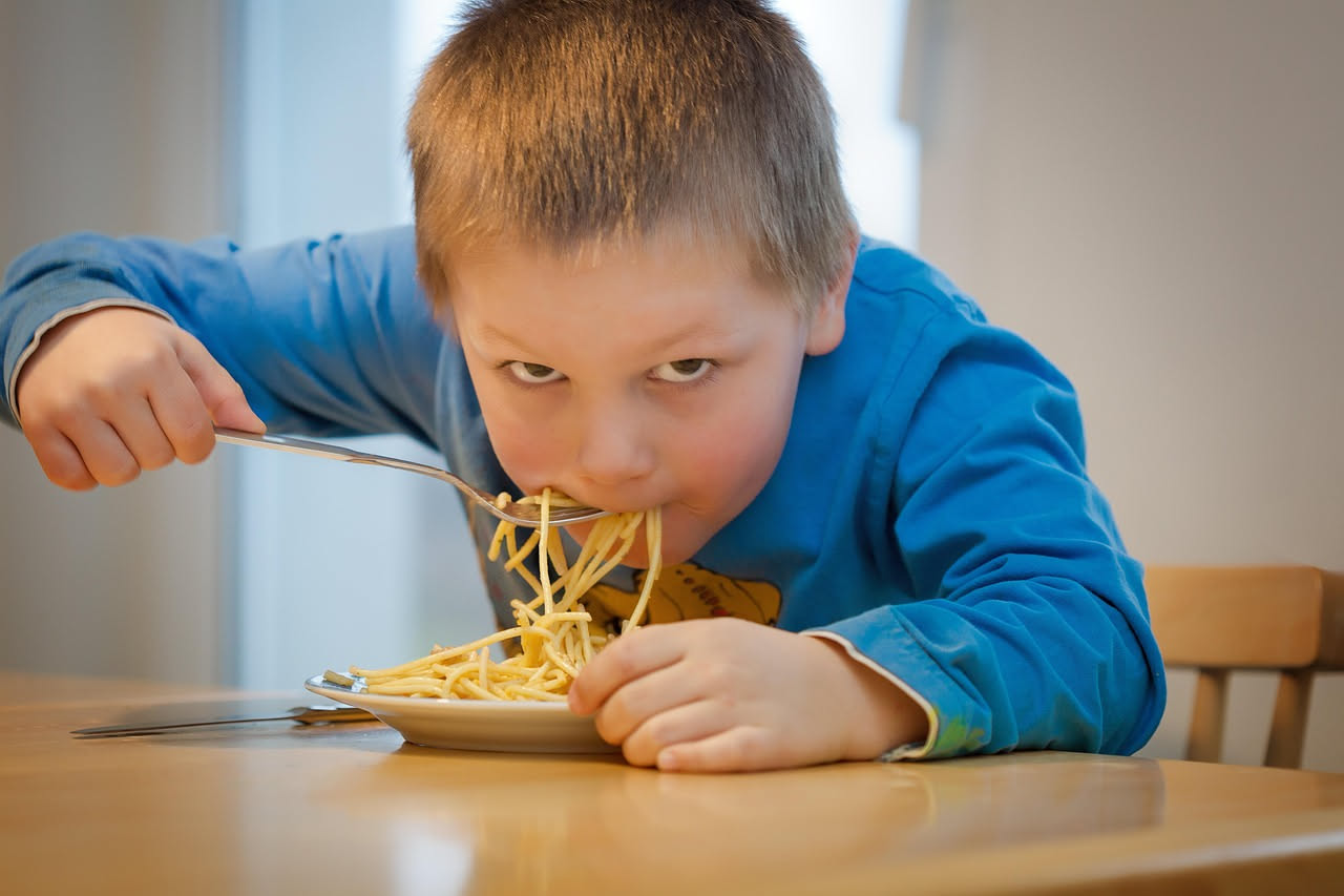 Tonnarelli cacio e pepe in bianco serviti in un piatto fondo di terracotta, ricoperti di pecorino grattugiato fine e grani di pepe nero tostato visibili, con una forchetta accanto