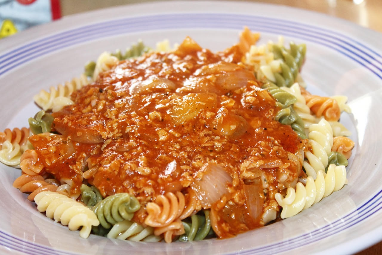 Trippa alla senese in un piatto bianco fondo, con brodo rosso dal pomodoro, pezzi di trippa morbida, pepe nero visibile in superficie