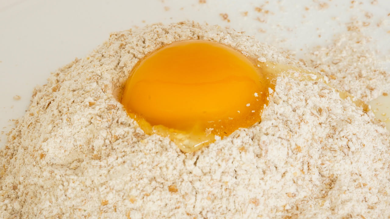 Uova sode tagliate a metà ripiene di formaggio fresco bianco, disposte su un piatto bianco con prezzemolo fresco, sfondo neutro