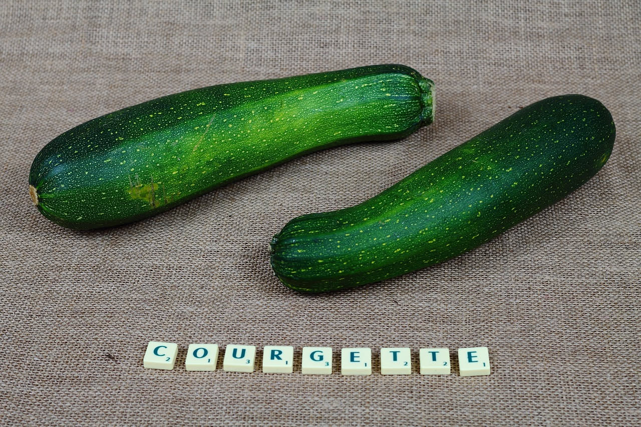 Zucchine fritte dorate e croccanti, marinate in aceto con foglie di menta fresca, poste in una ciotola bianca su un tavolo di cucina